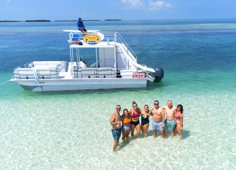 Fun In The Sun charter boat with guests at a sandbar, for up to six passengers